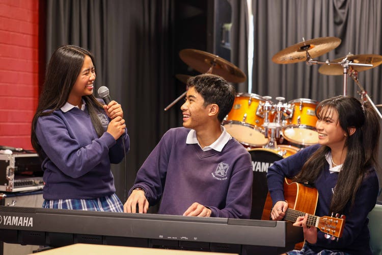 Three students performing in a music practice room